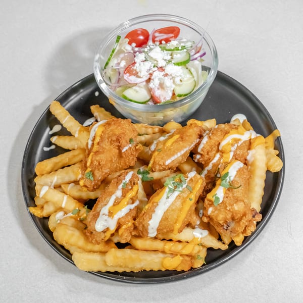 Crispy chicken tenders and crinkle-cut fries drizzled with cheese and white sauces, served with a fresh cucumber-tomato salad.
